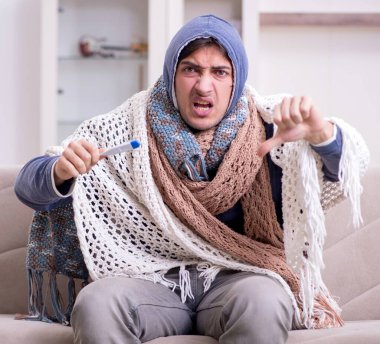 Evde acı çeken genç adam.