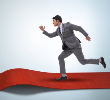 Başarı konseptinde kırmızı halıdaki iş adamı.