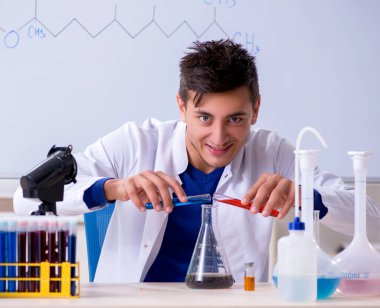 Laboratuvarda oturan genç kimyager.