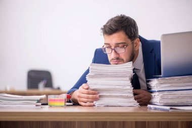 Genç işadamı ve ofiste çok fazla iş var.