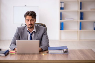 Genç işadamı işyerinde oturuyor.