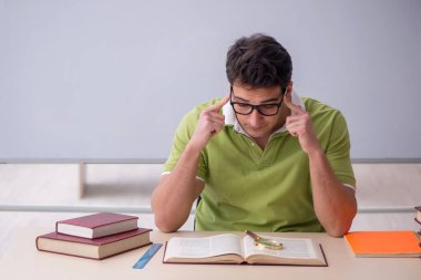 Sınıfta oturan genç öğrenci.