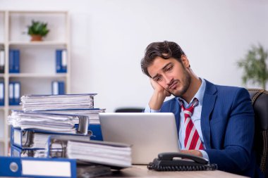 Genç işadamı ve ofiste çok fazla iş var.