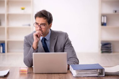 Genç işadamı işyerinde oturuyor.