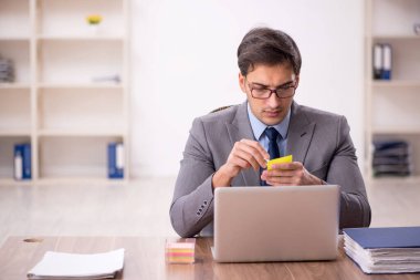 Genç işadamı işyerinde oturuyor.