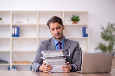 Genç işadamı işyerinde oturuyor.