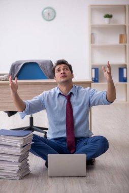 Young employee unhappy with excessive work at workplace