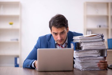 Genç işadamı işyerinde oturuyor.