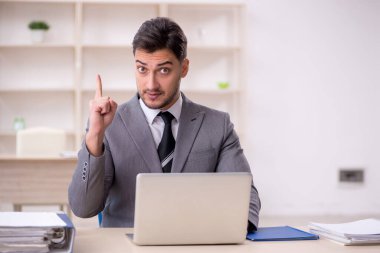 Genç işadamı işyerinde oturuyor.