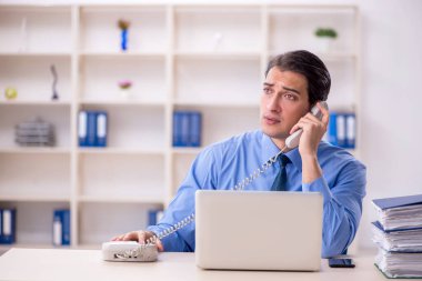 Genç işadamı ve işyerinde çok fazla iş var.