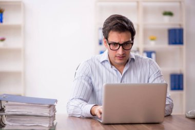 Genç işadamı ve işyerinde çok fazla iş var.