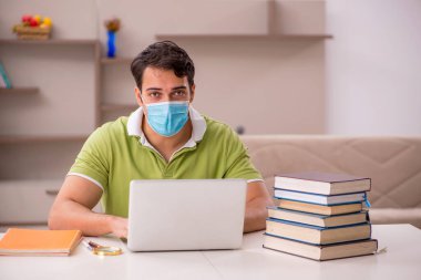 Genç öğrenci salgın sırasında evde sınavlara hazırlanıyor.