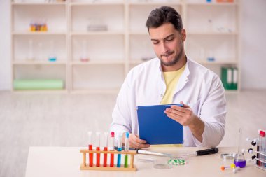 Young chemist sitting at the lab