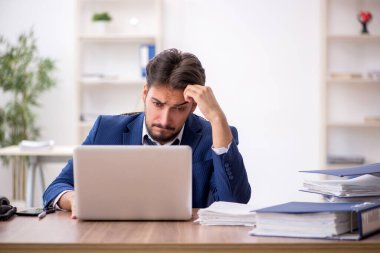 Genç işadamı ve ofiste çok fazla iş var.