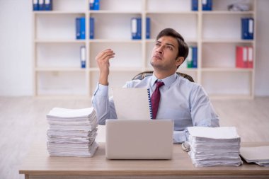 Genç işadamı ve ofiste çok fazla iş var.