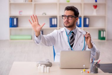 Young doctor holding phonendoscope at the hospital