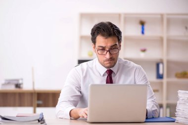 Genç işadamı ve işyerinde çok fazla iş var.