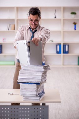 Young employee and too much work at workplace