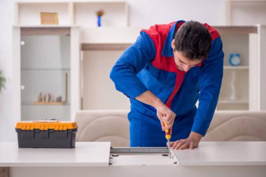 Evde çalışan genç bir marangoz.