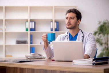Young doctor drinking tea during break