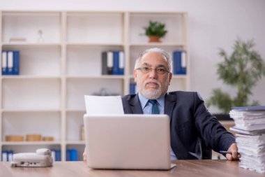 Ofiste çalışan eski bir işadamı.