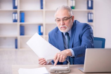 Eski bir işadamı ve işyerinde çok fazla iş var.