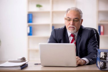 Ofiste çalışan eski bir işadamı.