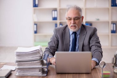 Old employee wearing spacesuit in the office
