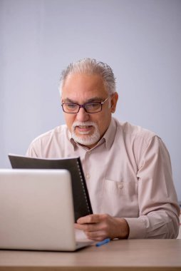 Eski öğretmen beyaz tahtanın önünde.