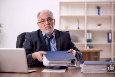 Ofisteki aşırı işten memnun olmayan eski bir işadamı.