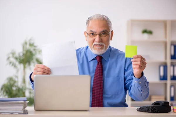 Old businessman employee working at workplace