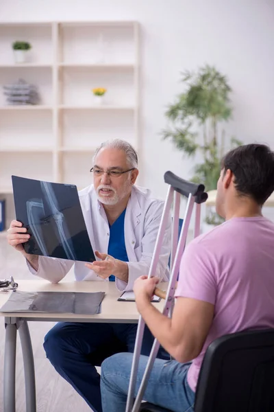 Young Leg Injured Patient Visiting Old Doctor Radiologist — Stock Photo, Image