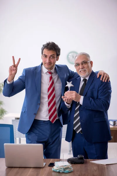 Two male employees with star award in the office