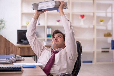 Genç işadamı ve işyerinde çok fazla iş var.