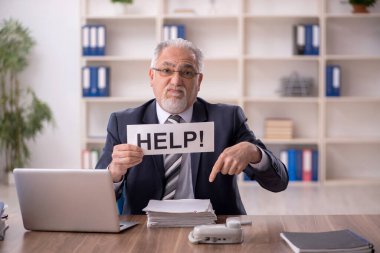 Old businessman employee unhappy with excessive work at workplace