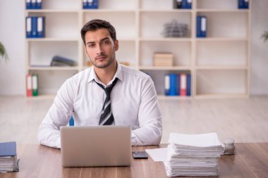 Genç işadamı işyerinde oturuyor.