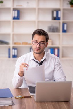 Genç işadamı işyerinde oturuyor.