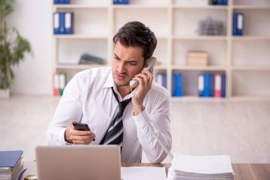 Genç işadamı işyerinde oturuyor.