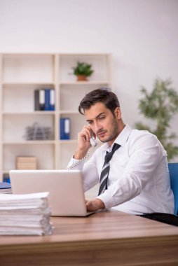 Genç işadamı işyerinde oturuyor.