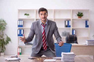 Genç işadamı işyerinde oturuyor.