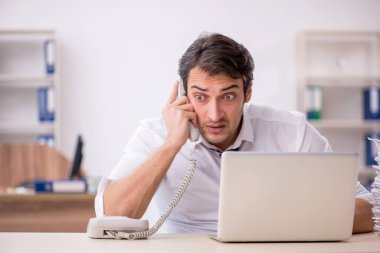 Genç işadamı ve işyerinde çok fazla iş var.