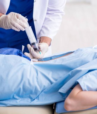 Kadın hasta klinikte iğne oluyor.