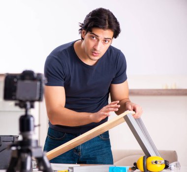 Genç erkek tamirci blogu için video kaydediyor.
