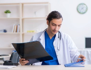 Klinikte çalışan genç erkek doktor.