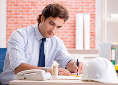 İnşaat yöneticisi planlar üzerinde çalışıyor.