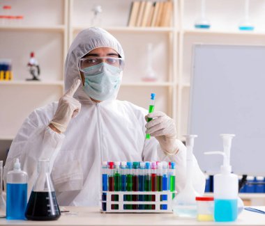 Laboratuvarda çalışan genç yakışıklı kimyager.