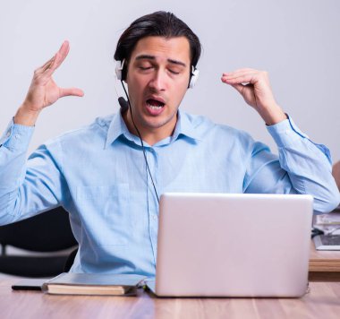 Masasında çalışan çağrı merkezi operatörü.