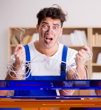 Kablolara dolanmış komik genç elektrikçi.