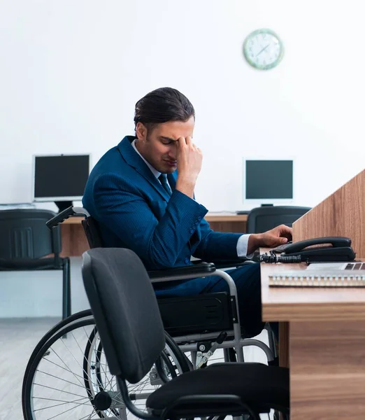 The young male employee in wheel-chair