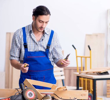 İçeride çalışan genç erkek marangoz.